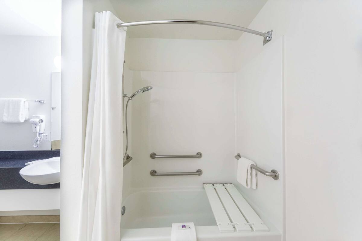 A bathroom with a shower, a toilet, and a sink.