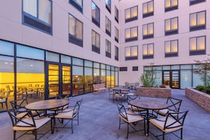 A courtyard with outdoor seating and a glass facade. - Staybridge Suites Seattle - Fremont by IHG (Seattle)