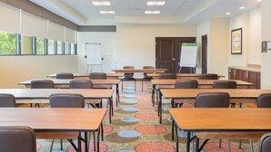 A conference room with multiple tables and chairs, a whiteboard, and a door with a sign. - Staybridge Suites Seattle - Fremont by IHG (Seattle)