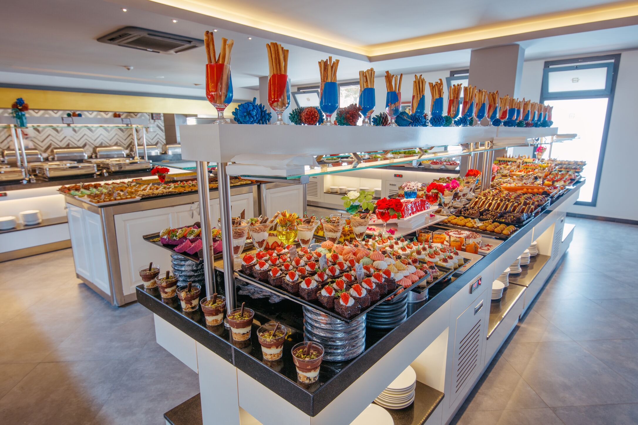 Un bufé con diversos alimentos y postres.
