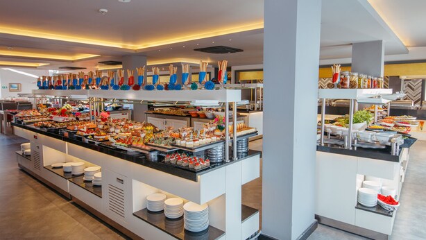 A buffet with various food items and utensils.