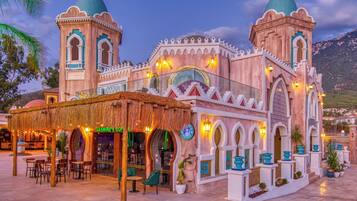 A traditional building with two domed towers, a covered seating area, and a shop named "Jasmine's Coz."