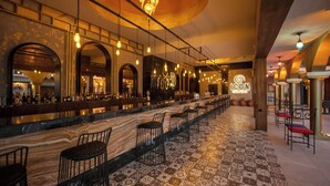 A bar area with a long counter, multiple seating options, and a patterned floor. - Orka World Hotel & Aquapark (Fethiye)