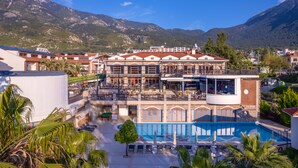 A hotel with a pool, outdoor seating, and mountain views. - Orka World Hotel & Aquapark (Fethiye)
