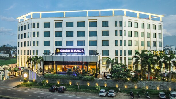 A multi-story hotel with a prominent 'Grand Estancia' sign, featuring a modern architectural design with a flat roof and uniform windows. - Grand Estancia (Salem)