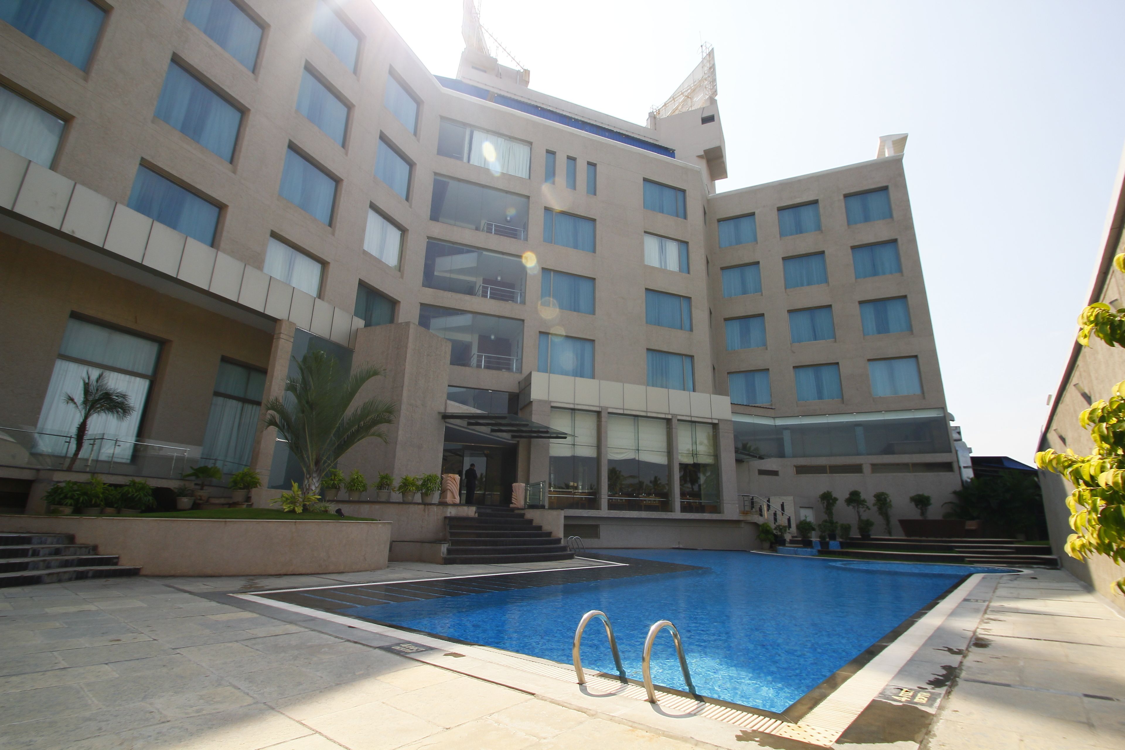 Un hôtel moderne doté d’une piscine, de nombreux balcons et d’un espace extérieur bien aménagé.