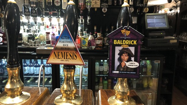 A bar with three taps labeled Nemesis, Alton Peakstones Rock, and Baldrick. - The Dog and Partridge Country Inn (Ashbourne)
