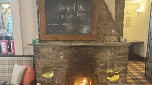 A fireplace with a sign above it reading "Soup of the Day" and "Carla Cheese." - The Dog and Partridge Country Inn (Ashbourne)