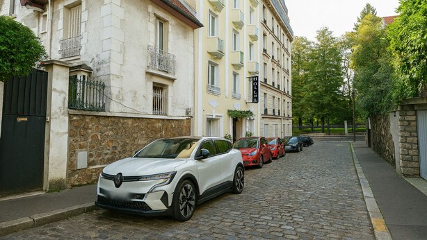 A cobblestone street lined with parked cars and buildings. - Hôtel du Parc Montsouris (Paris)