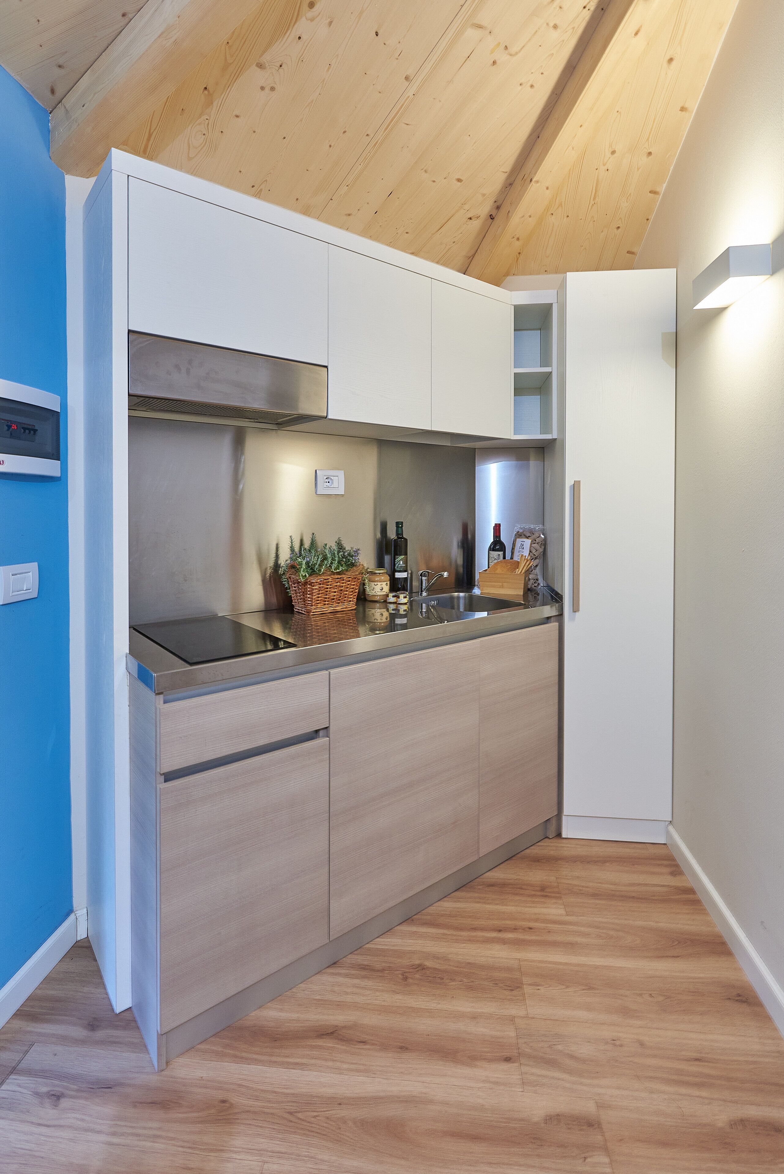 A modern kitchen with wooden cabinets, a stainless steel sink, and a built-in oven.