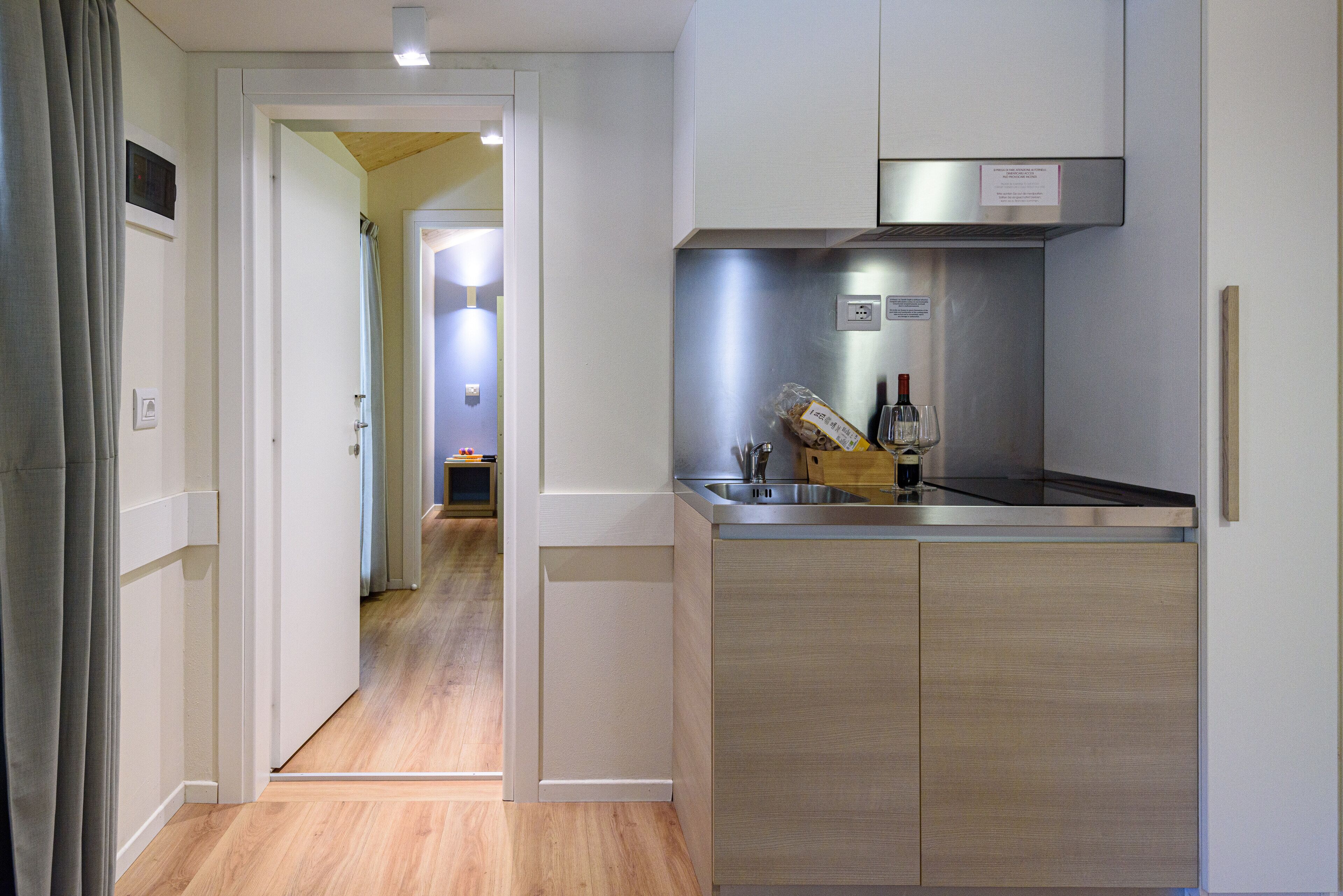A modern kitchen with stainless steel appliances, wooden cabinets, and a built-in oven.
