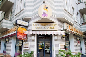 Un café à la façade rayée, avec une enseigne indiquant qu’il s’agit d’un bar à cocktails.