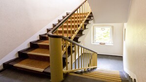 A staircase with wooden steps and a metal railing. - Pension Odin (Berlin)