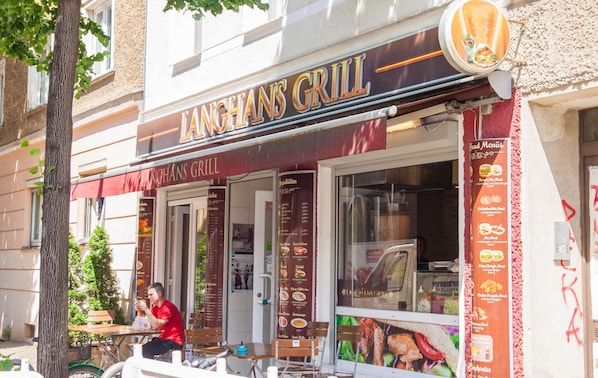 Un restaurant appelĂ© Langhans Grill, dotĂ© dâune terrasse et dâun panneau affichant le menu.