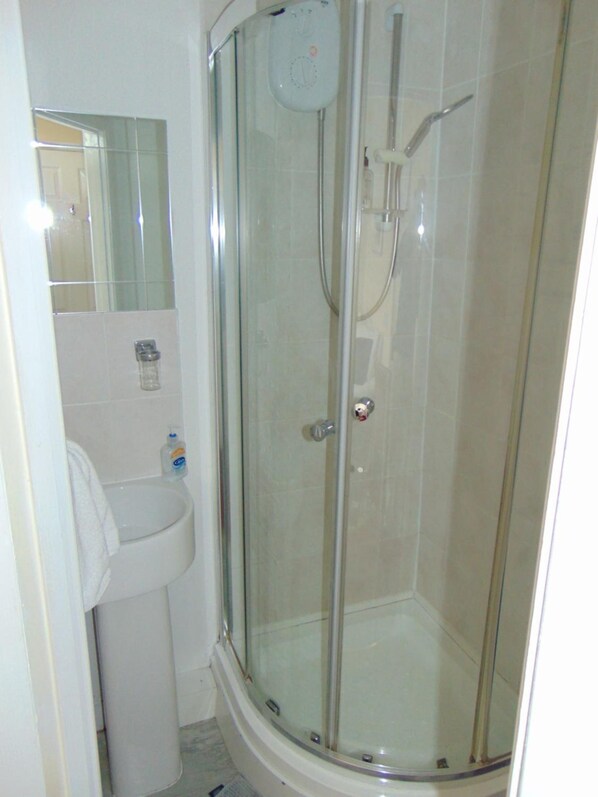 A glass-enclosed shower with a handheld showerhead and a wall-mounted control panel. - White House View Guest House (Oxford)