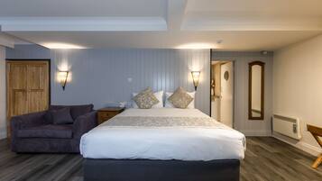 Un dormitorio con cama, sofá y dos luces fijadas en la pared.