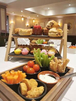 A buffet setup with various food items including pastries, fruits, and dips.