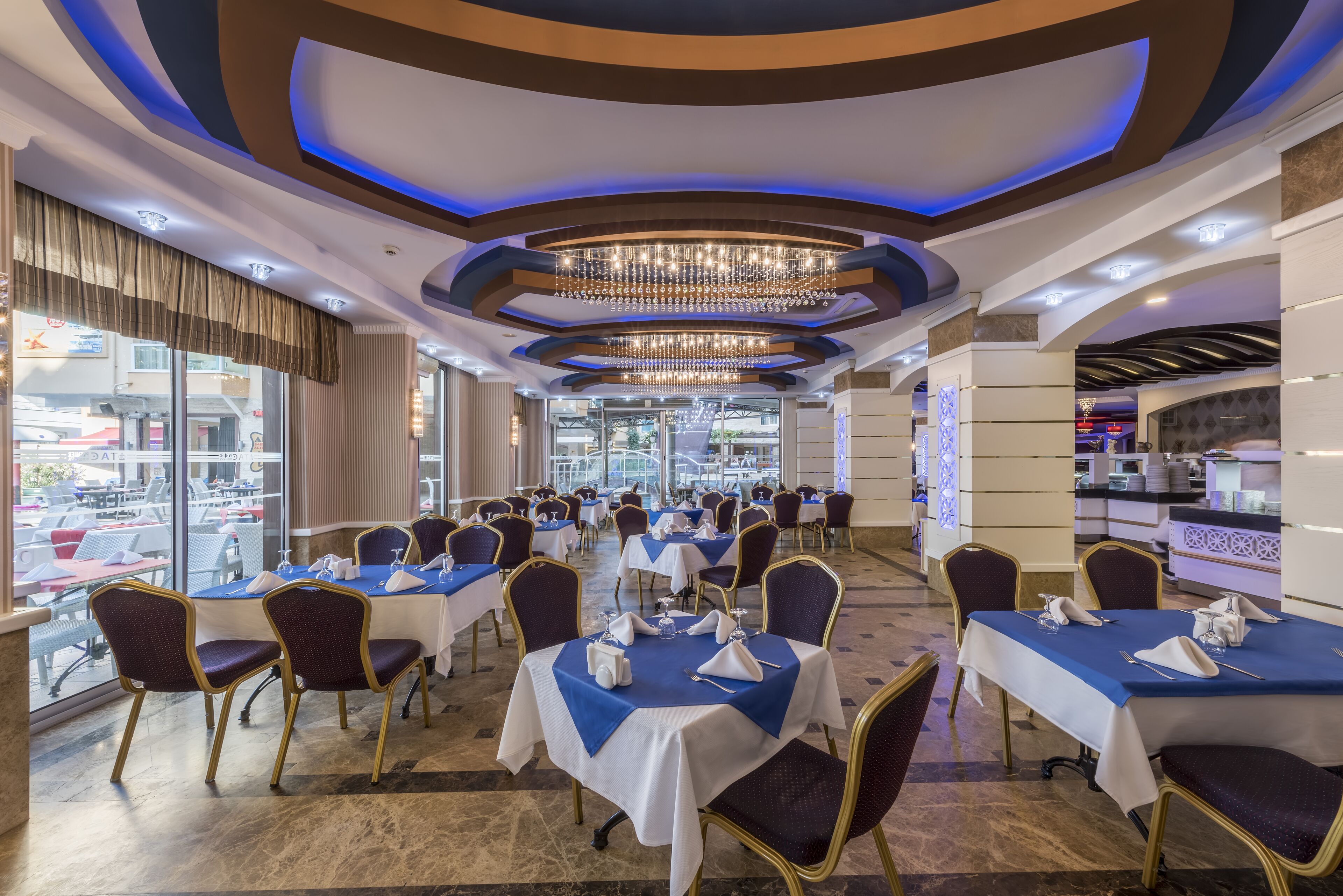 Un restaurant doté de nombreuses tables, de chaises et d’un lustre.