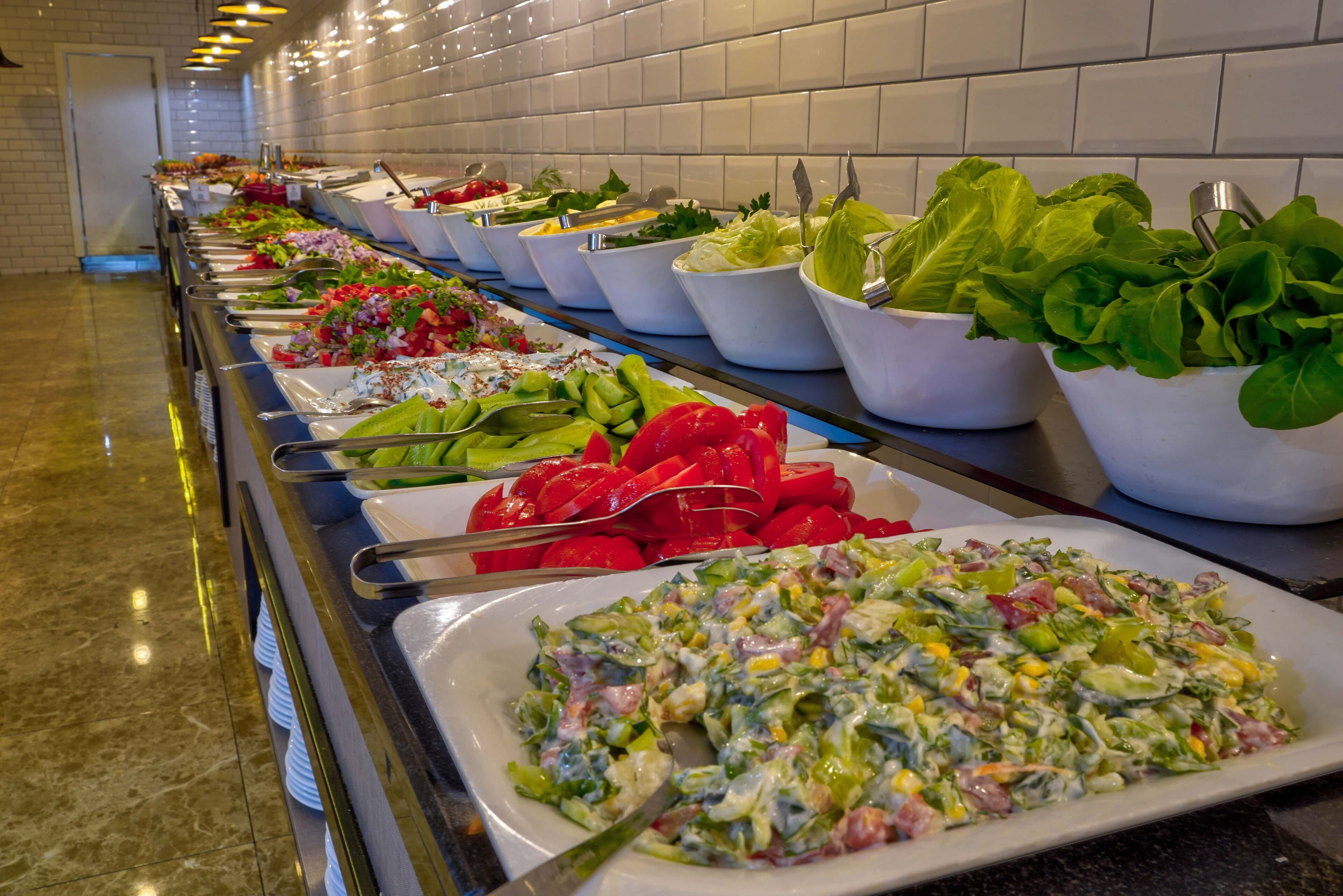 Un buffet con insalate e verdure assortite.