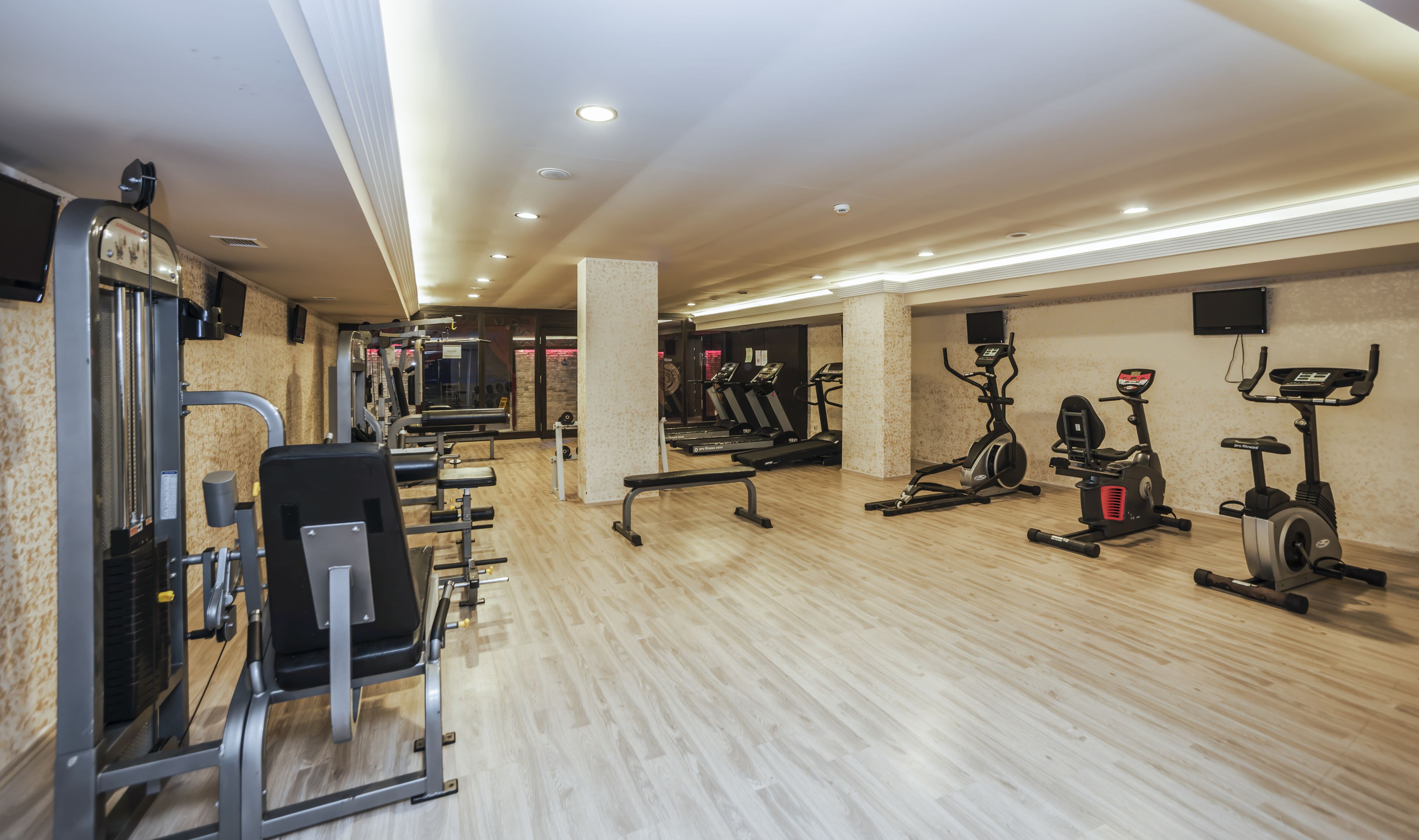 A modern gym with various exercise equipment, including treadmills, elliptical machines, and weight machines.