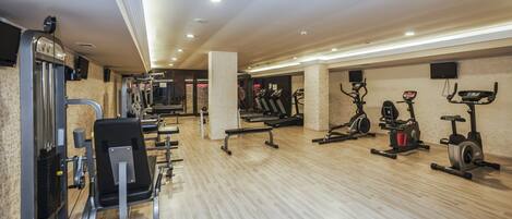A modern gym with various exercise equipment, including treadmills, elliptical machines, and weight machines.