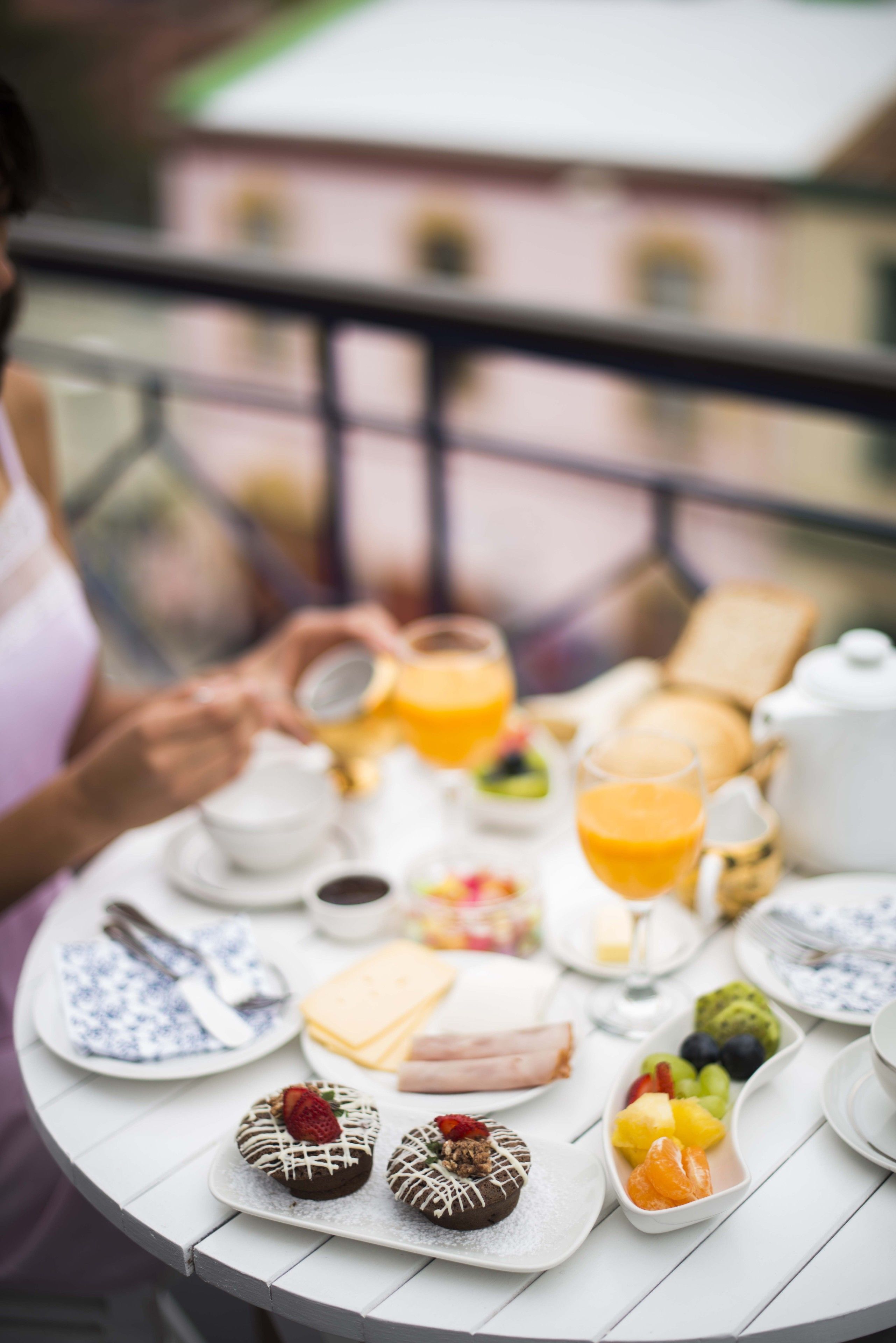 Una bandeja de desayuno con diversos alimentos y bebidas sobre una mesa blanca.