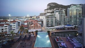 A rooftop pool area with lounge chairs and a view of a mountain. - Sunborn Gibraltar Yacht Hotel Resort (Gibraltar)