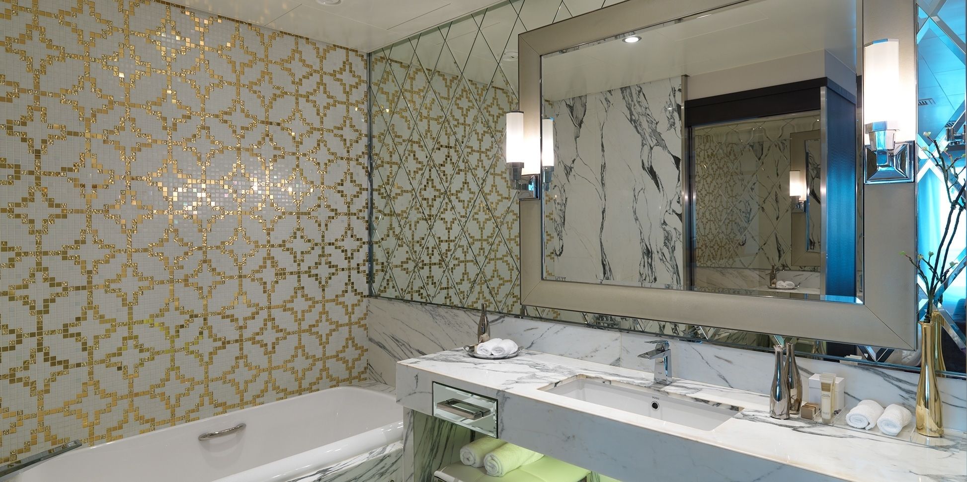 Un bagno moderno con una vasca, un mobile lavabo con specchio e pareti decorate.