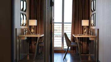 Ein Hotelzimmer mit zwei Schreibtischen, Stühlen und Lampen.