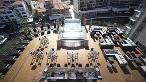 A rooftop bar with lounge chairs, a pool, and a bar area. - Sunborn Gibraltar Yacht Hotel Resort (Gibraltar)