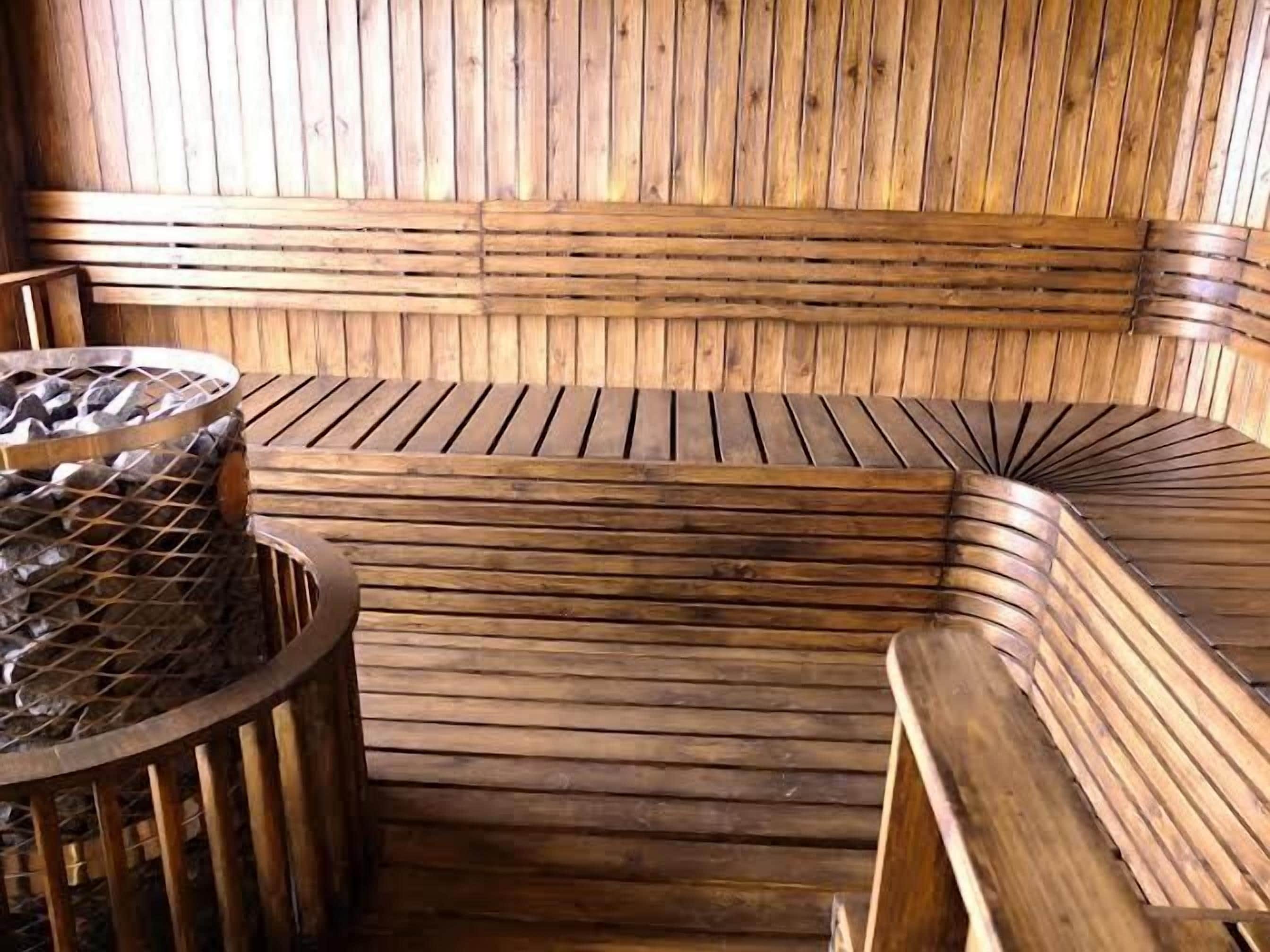 A wooden sauna with benches and a stone basin.