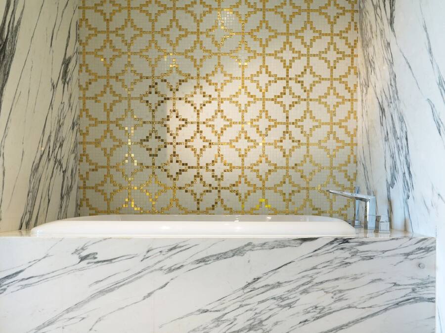 Un baño con lavamanos de mármol y bañera.