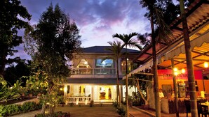 A two-story building with a covered outdoor area and a restaurant adjacent to it. - The Legend Maeklong (Samut Songkhram)