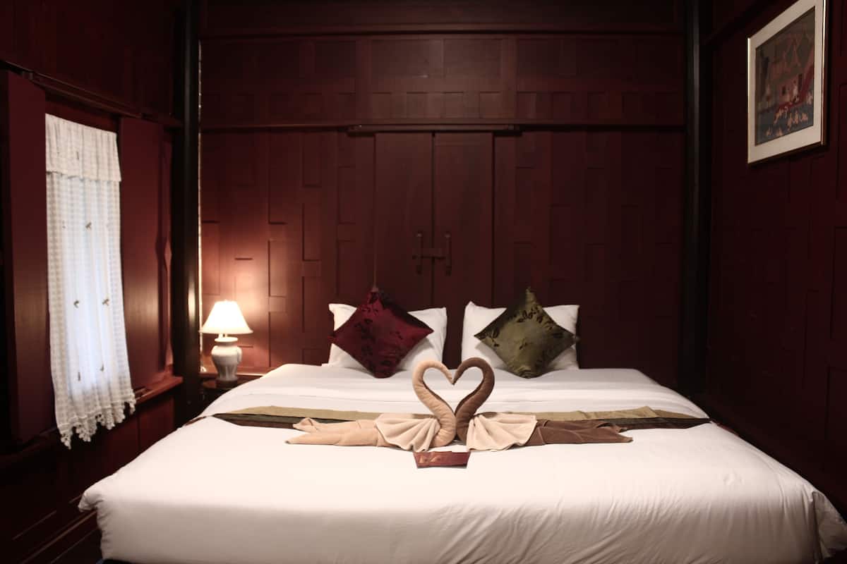 Una habitación de hotel con una cama bien hecha, una lámpara en la mesita de noche y un cuadro en la pared.