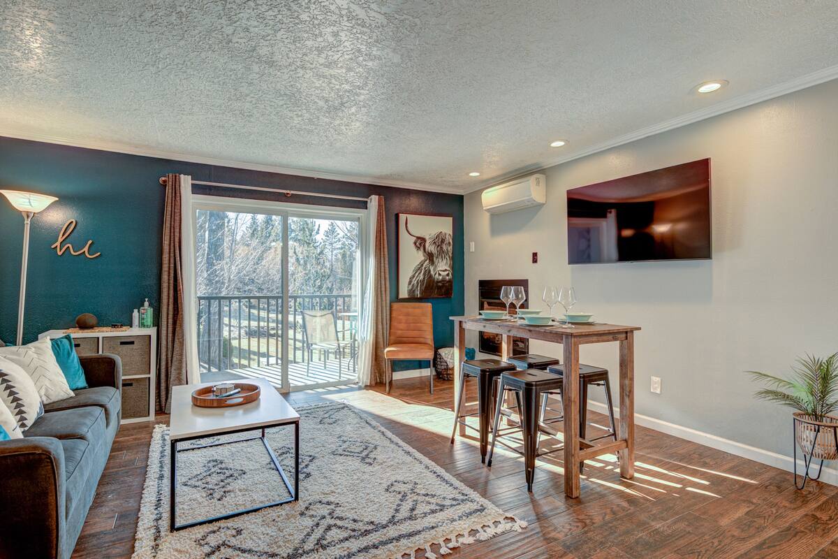 A living room with a sofa, coffee table, and a dining area with a table and chairs.
