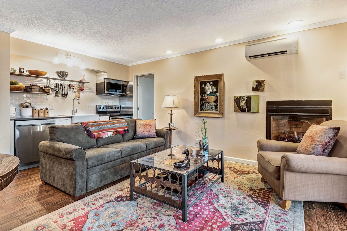 A living room with a sofa, coffee table, and fireplace.