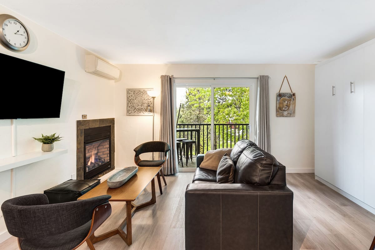 A living room with a fireplace, a sofa, a dining table, and a TV.