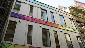 A multi-story building with large windows and a geometric facade design. - ColorMix Hotel & Hostel (Taipei)