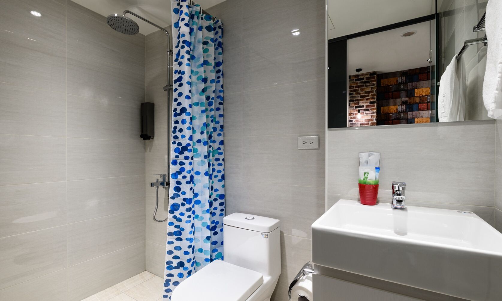 Een moderne badkamer met douche, toilet en wastafel.