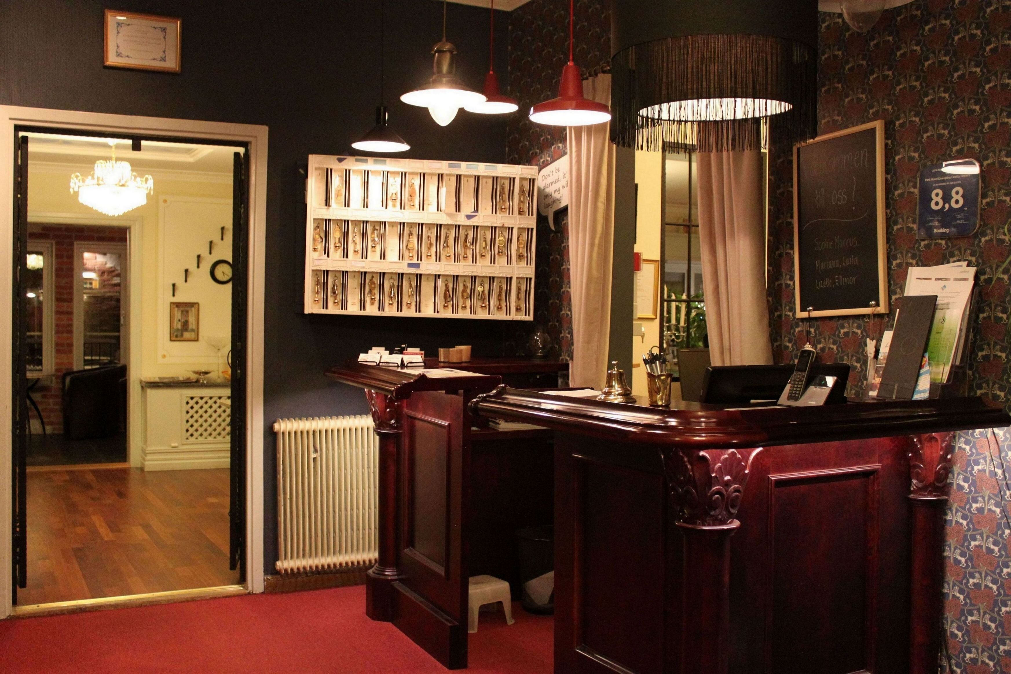 A reception area with a wooden desk, a bookshelf, and a mirror. There is a sign with the number 8.8 on the wall.