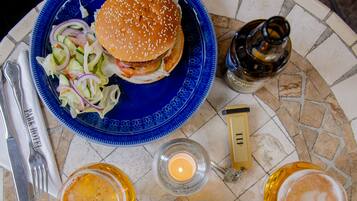 Una mesa con dos platos de comida, una botella y una vela.