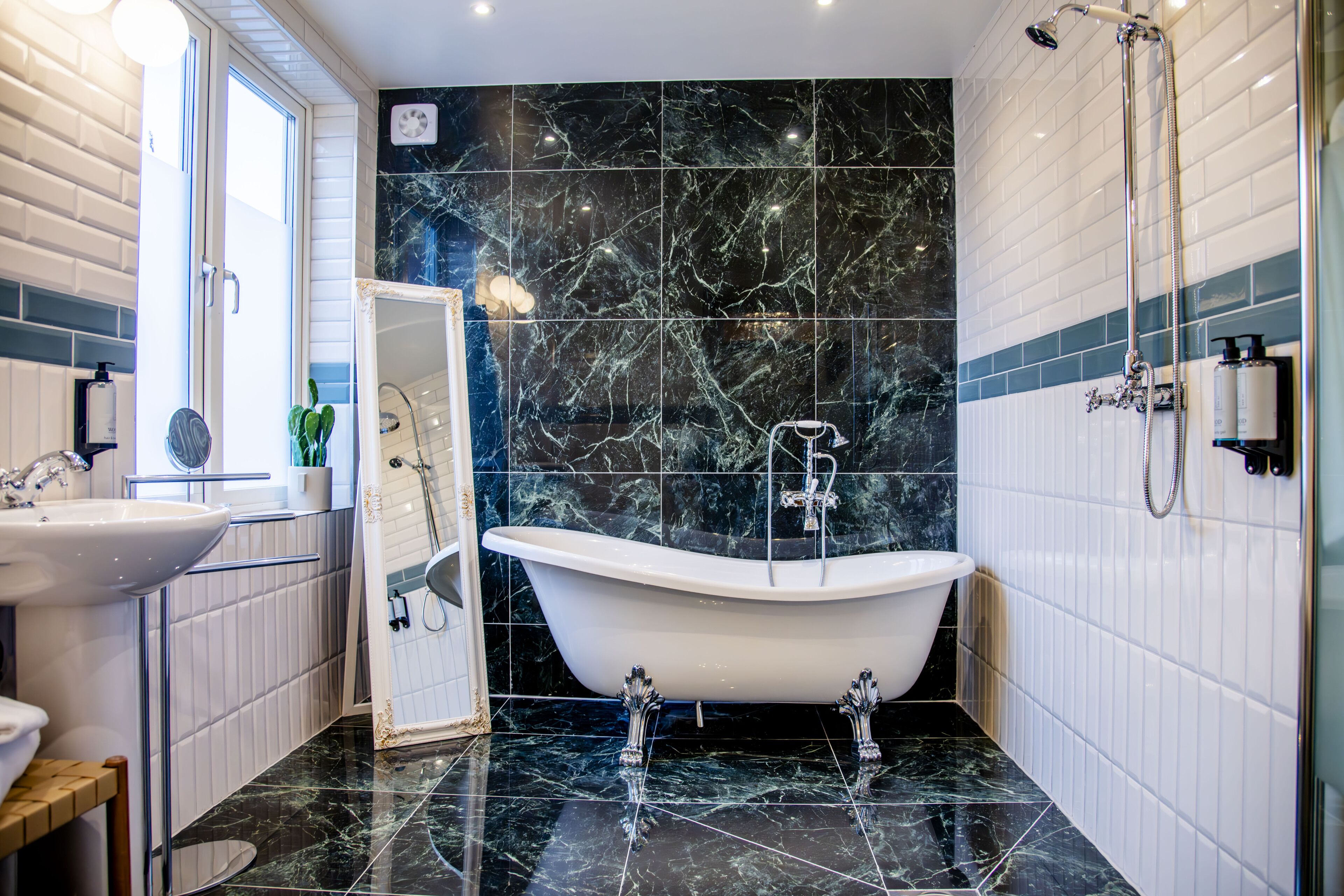 A bathroom with a bathtub, a sink, and a mirror.
