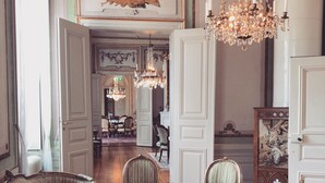 Une salle à manger élégante, ornée d’un lustre, de chaises décoratives et d’une table dressée pour quatre personnes.