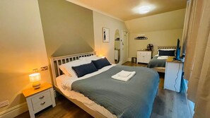 A bedroom with a bed, bedside table, and a desk with a chair. - Euro Bar and Hotel (Oxford)