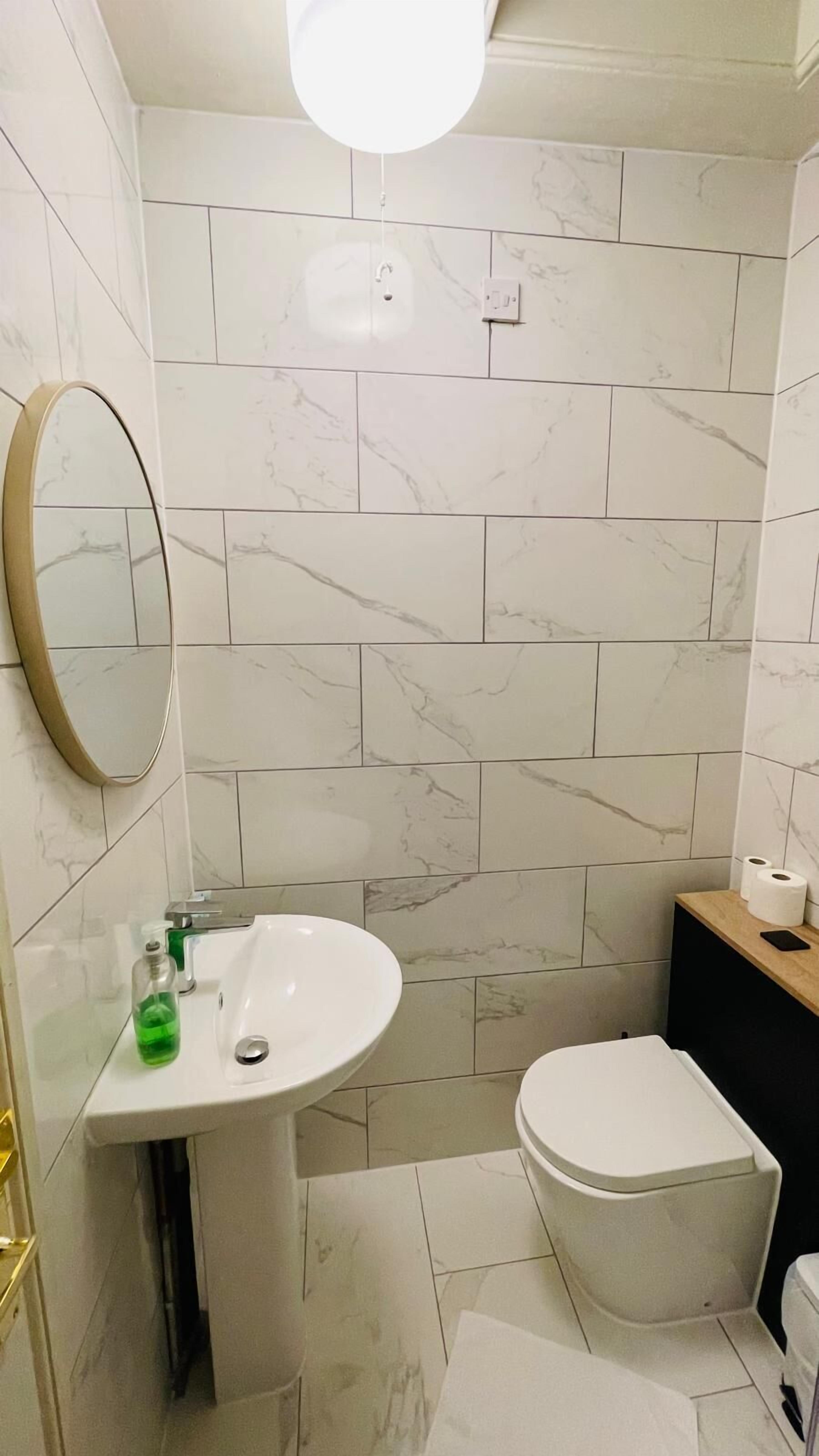 A bathroom with a white sink, a toilet, and a mirror.