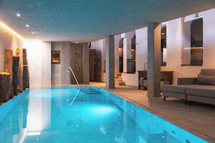 Una piscina cubierta, tumbonas