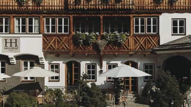 Un edificio tradizionale europeo con un balcone in legno, pareti bianche e un cartello con la scritta "Himmelhof".