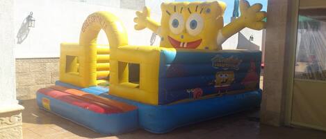 A large inflatable play structure with a character design, featuring a tunnel and slides.