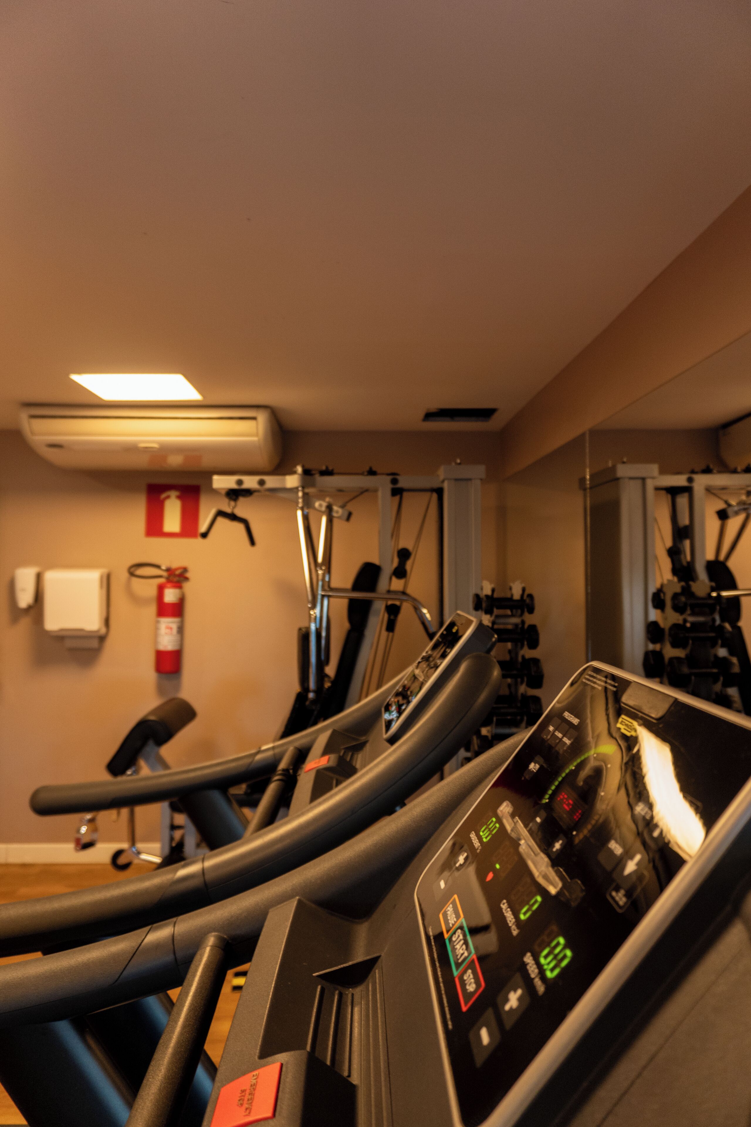 Une salle de sport équipée de tapis de course, de vélos d’appartement et d’appareils de musculation.