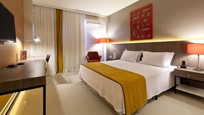 A hotel room with a bed, bedside tables, a desk, a chair, and a TV. - San Diego Suítes Veredas Sete Lagoas (Sete Lagoas)